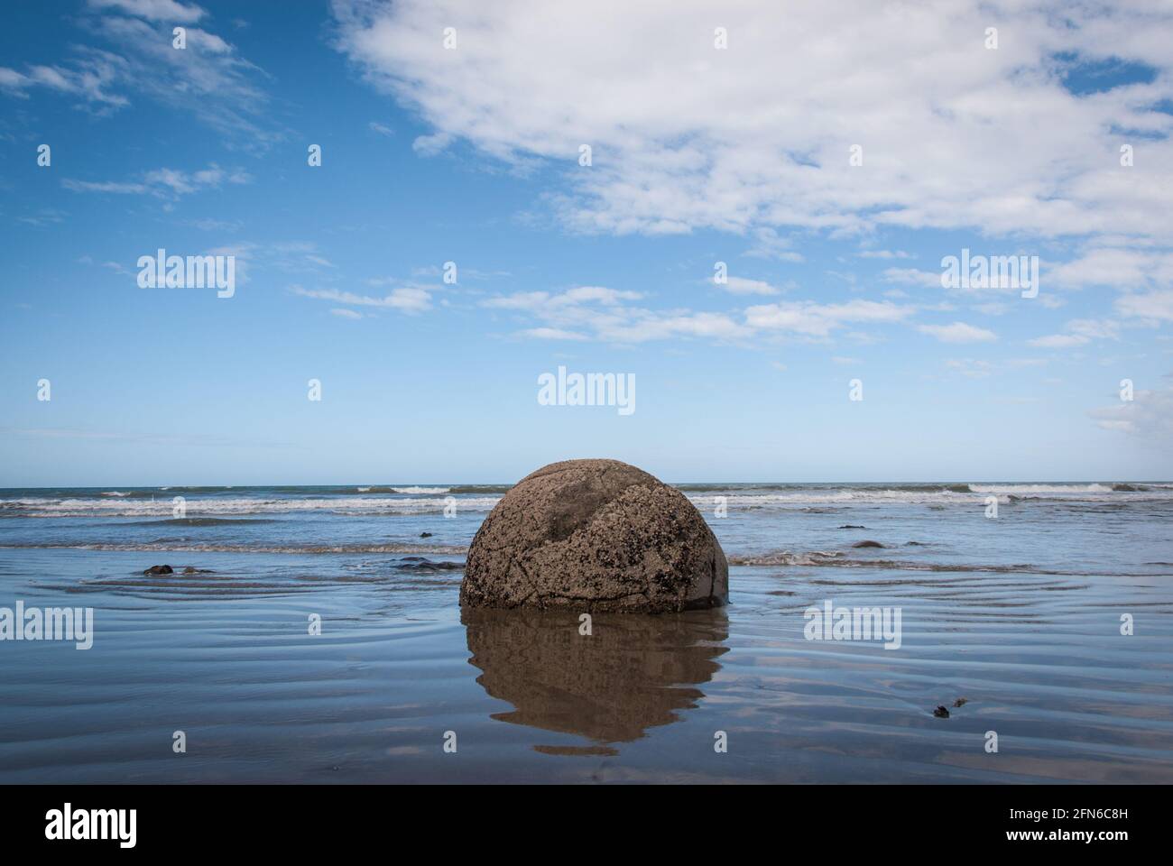 One of the Moeraki Boulders in the surf zone at Koekohe Beach on New Zealand's South Island. Stock Photo