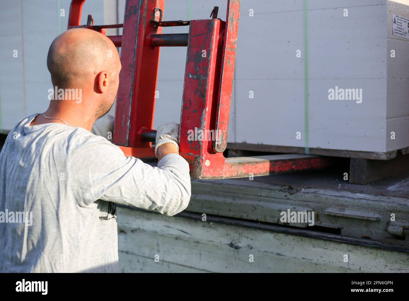 Unloading building blocks from a truck using a crane. Hydraulic ...