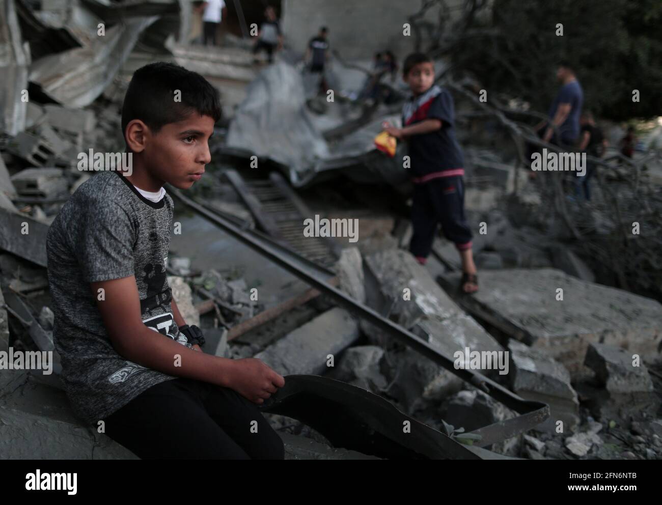 Gaza. 14th May, 2021. A Palestinian boy sits on the rubble of a house ...