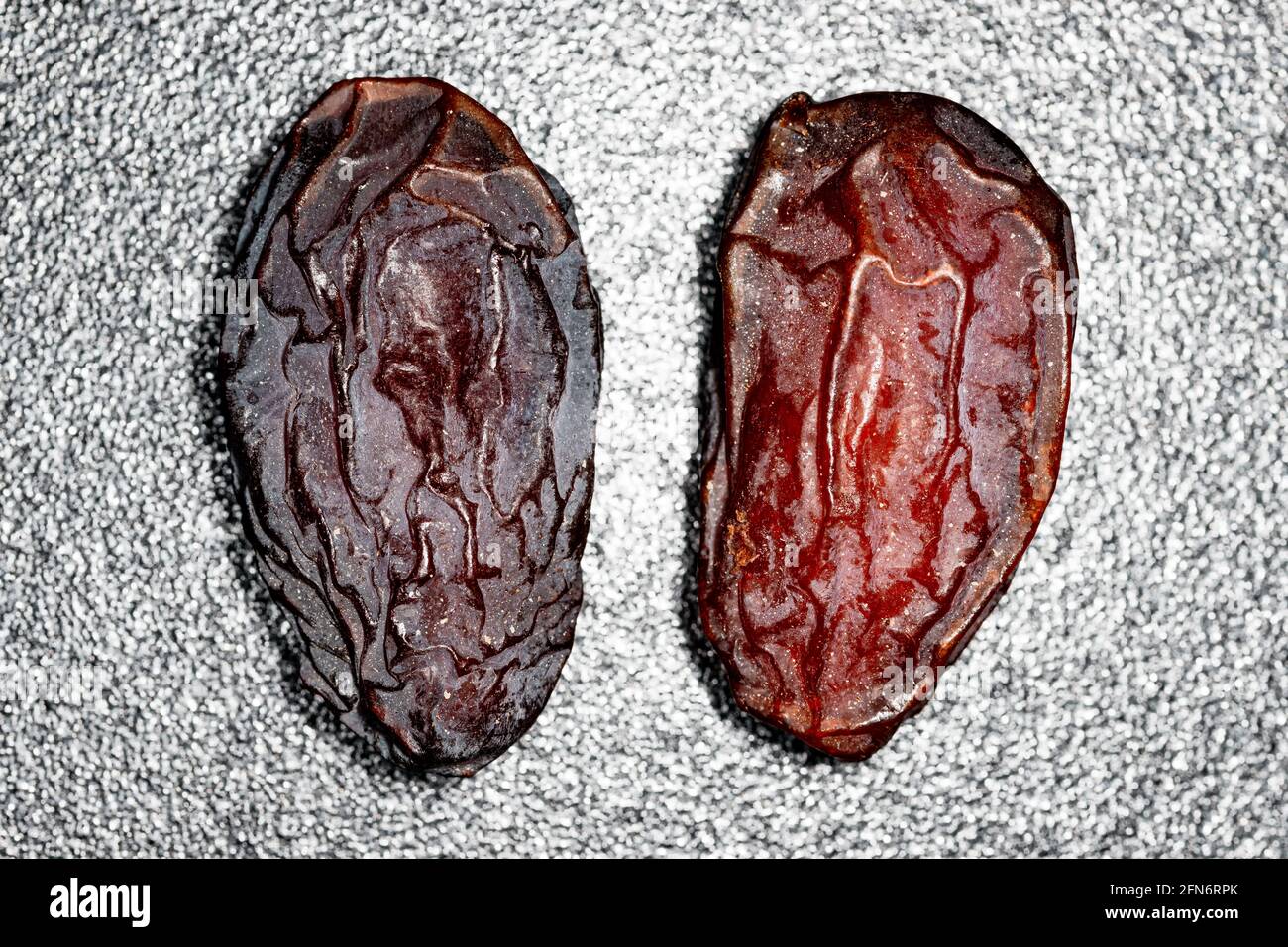 Two large dried dates on black and white background Stock Photo