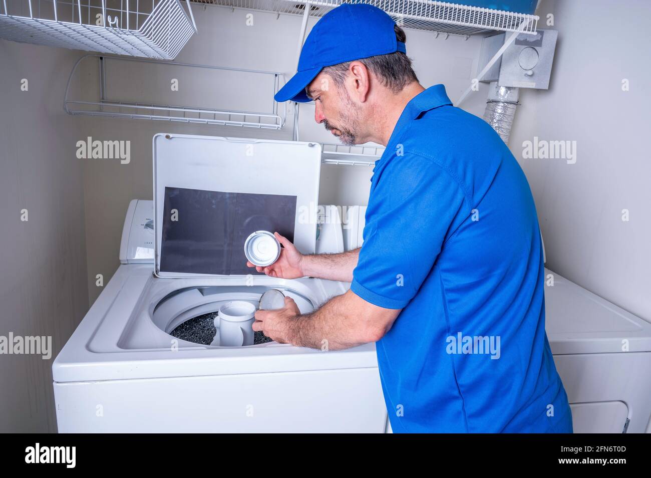 Appliance service technician inspecting the agitator of a washing