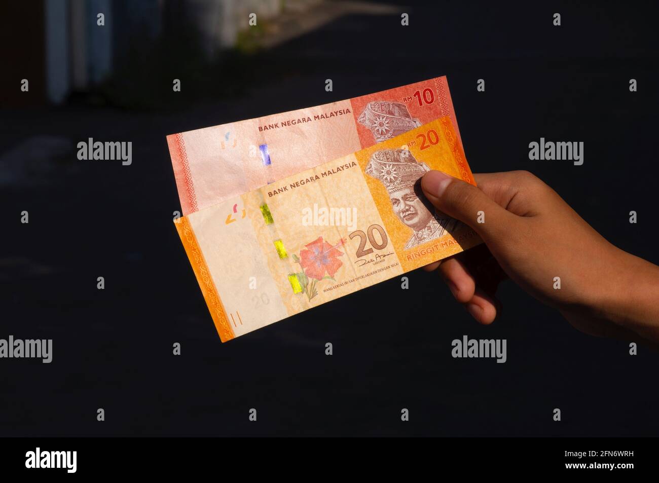 Asian Child Hand Holding 10 And 20 Ringgit Malaysia Money Shallow Focus On Dark Background Stock Photo Alamy
