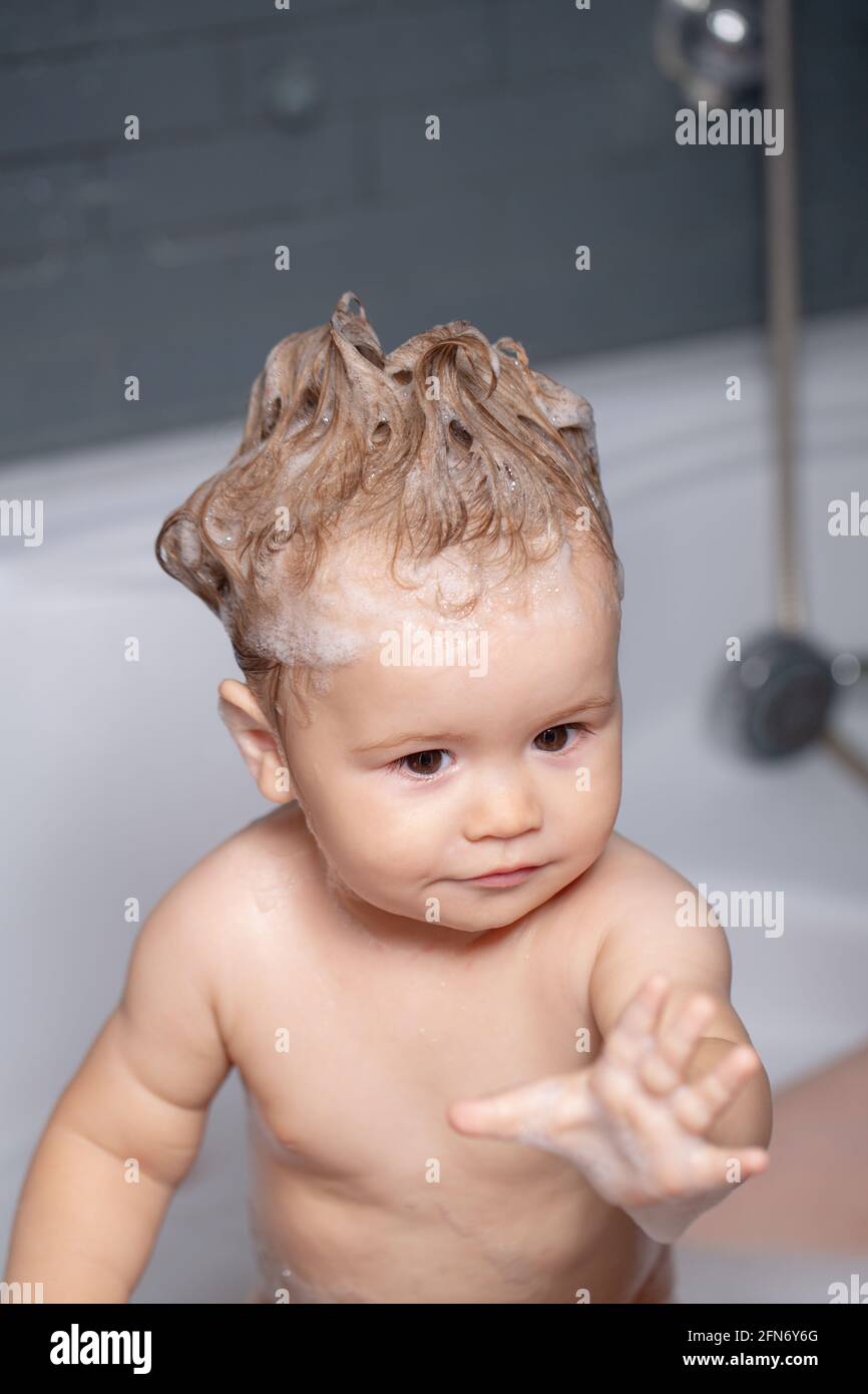 Kid bathing in bathroom. Little baby taking bath, closeup face portrait