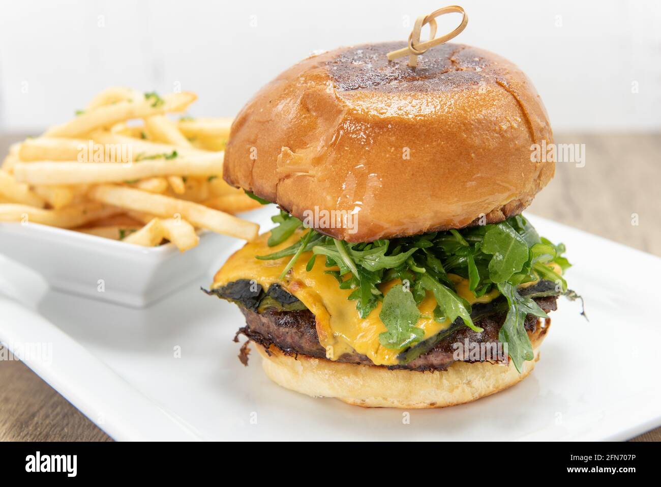Enormous cheeseburger loaded with hamburger patty and melted cheese included french fries. Stock Photo