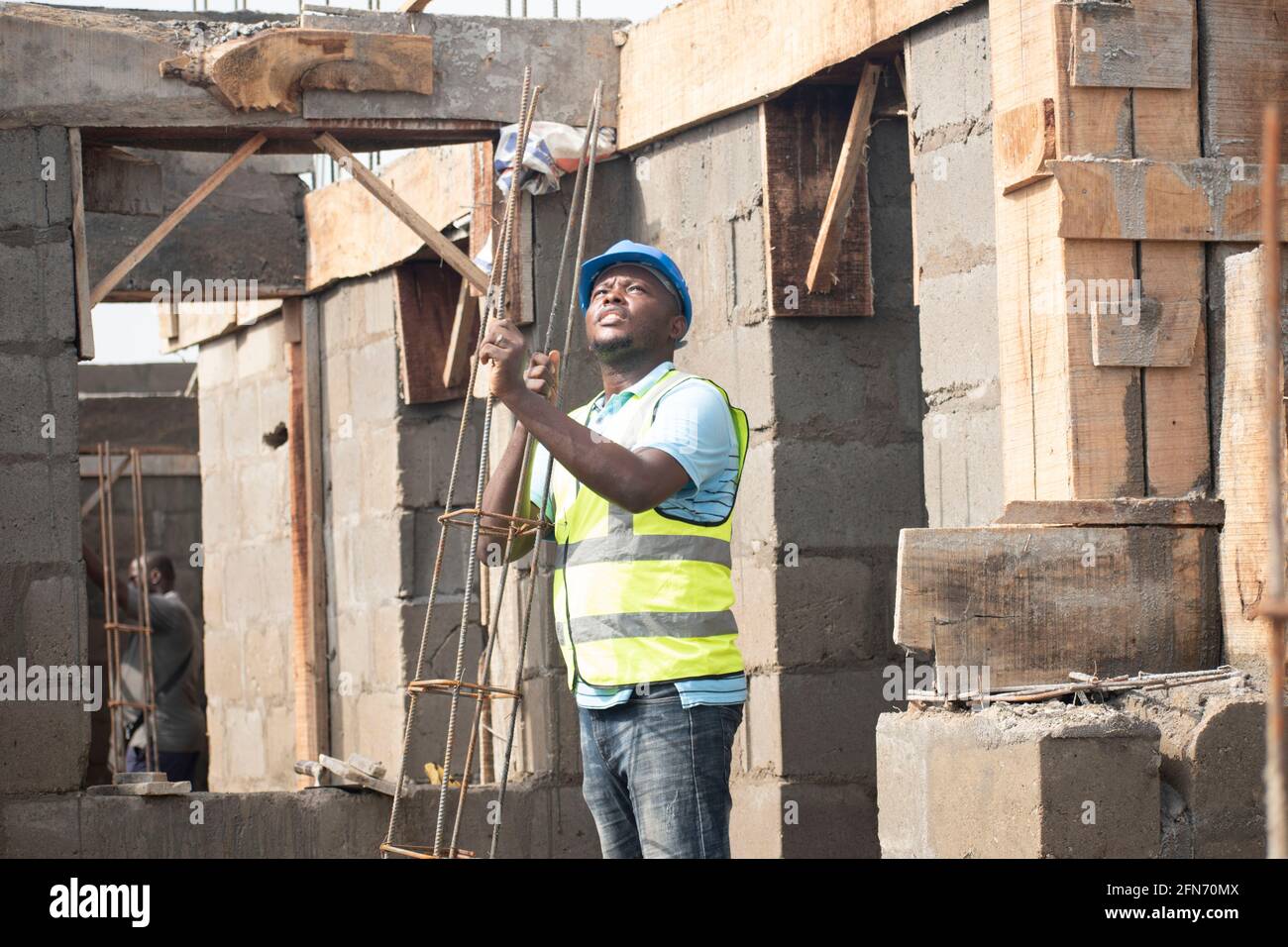 a carpenter carrying wood on site Stock Photo - Alamy