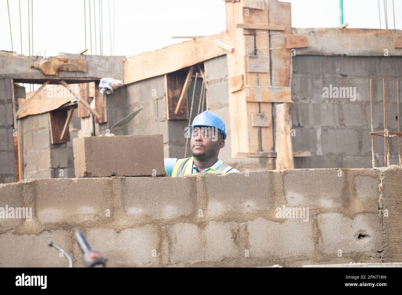 an african bricklayer laying bricks Stock Photo