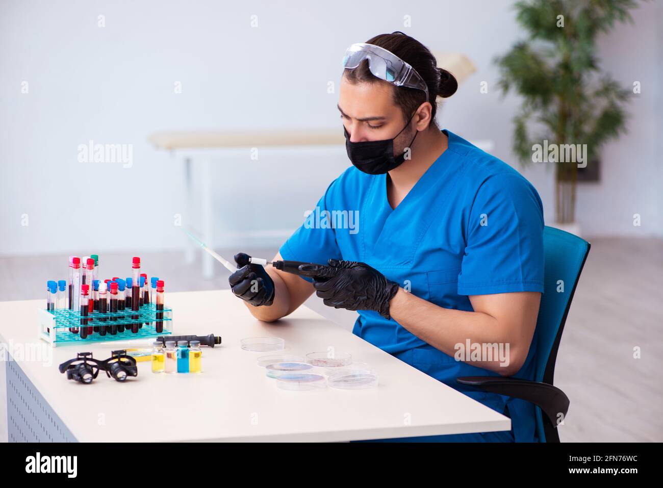 Male biochemist testing blood samples in pandemic concept Stock Photo ...