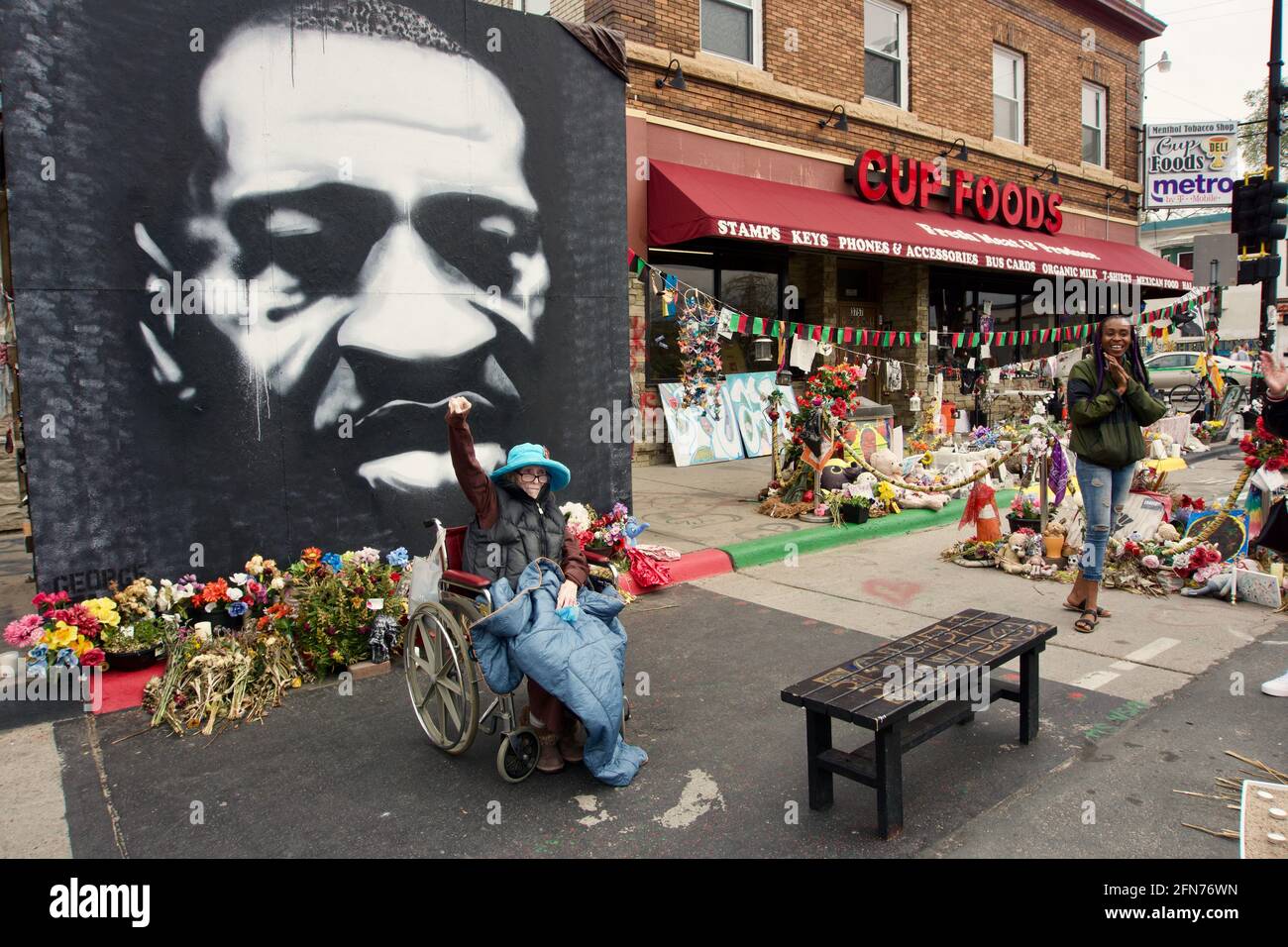 Karen Cato has late stage cancer, last wish was to visit George Floyd Square. Disabled elderly white woman with fist in air at mural. Minneapolis, MN. Stock Photo