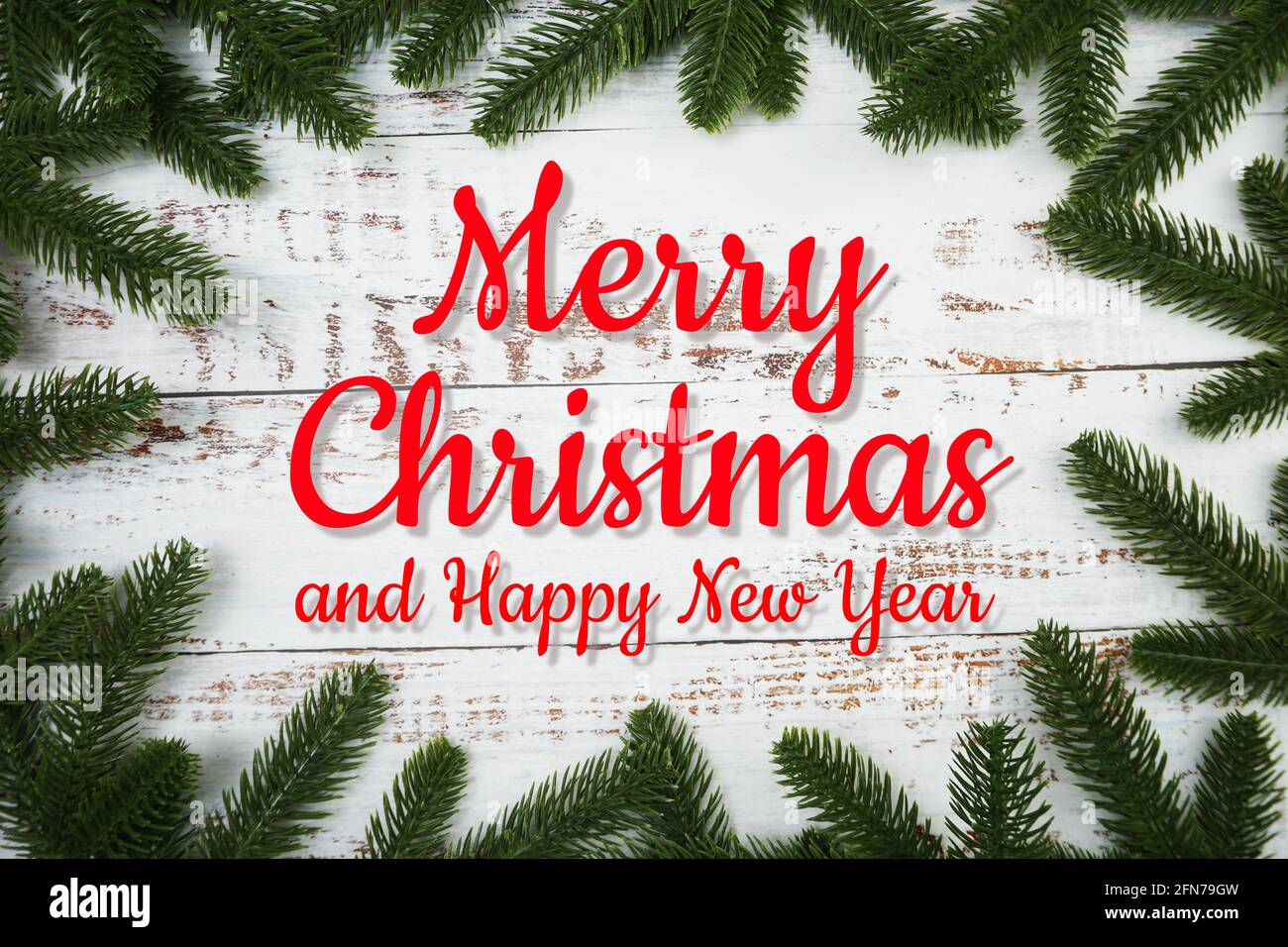 Merry Christmas text with fir tree branches border frame on wooden ...