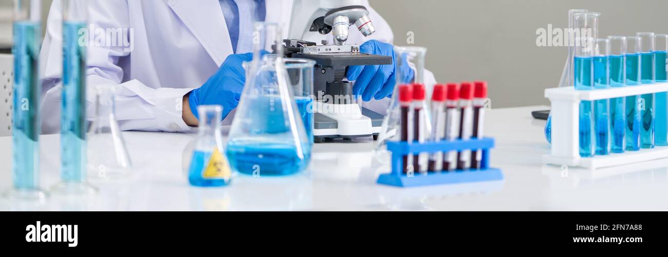 Scientist use microscopes to look at blood samples of infected people ...