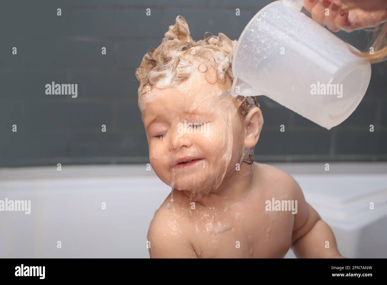 Hygiene and body care for children. Happy funny baby bathed in the bath Stock Photo Alamy