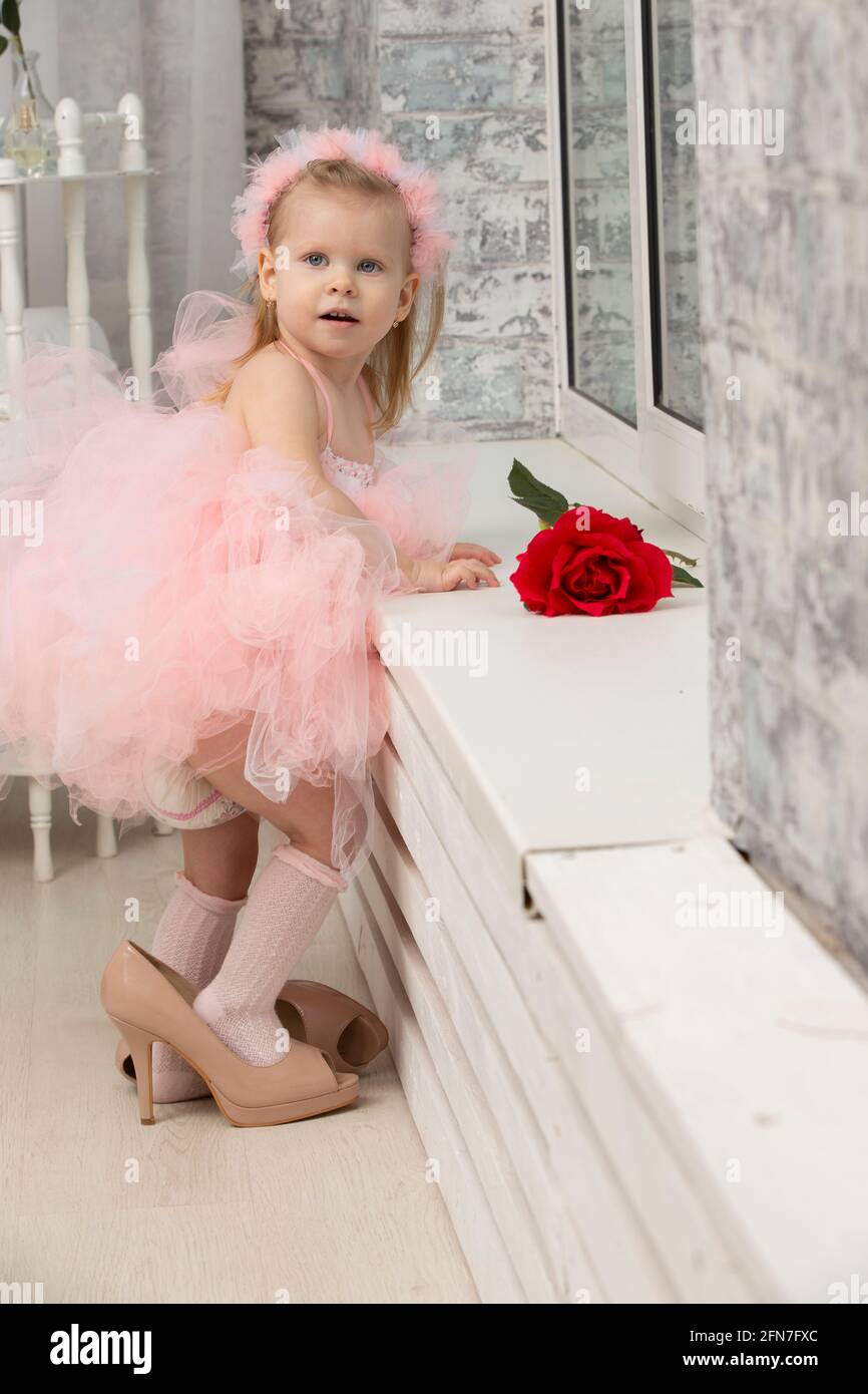 Little funny girl in a smart pink dress and high heel shoes Stock Photo -  Alamy