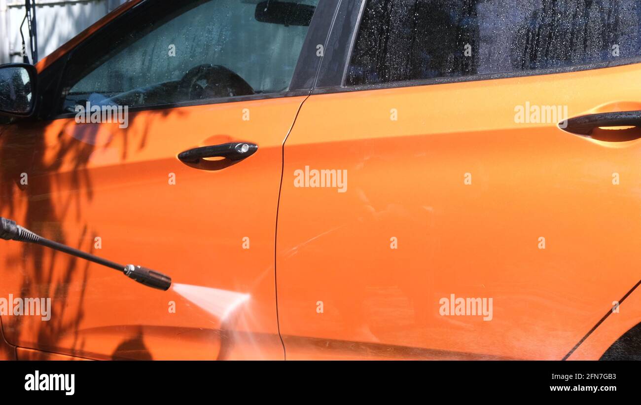 Manual car wash with pressurized water in car wash outside in summer