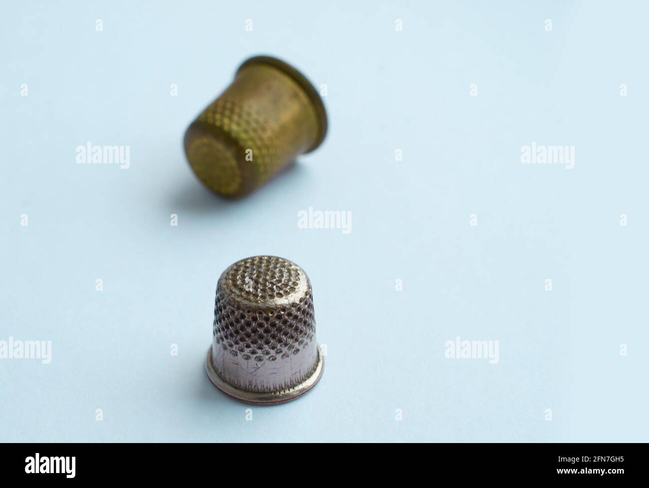 Two vintage thimbles stand in a row isolated on a colored background Stock Photo Alamy