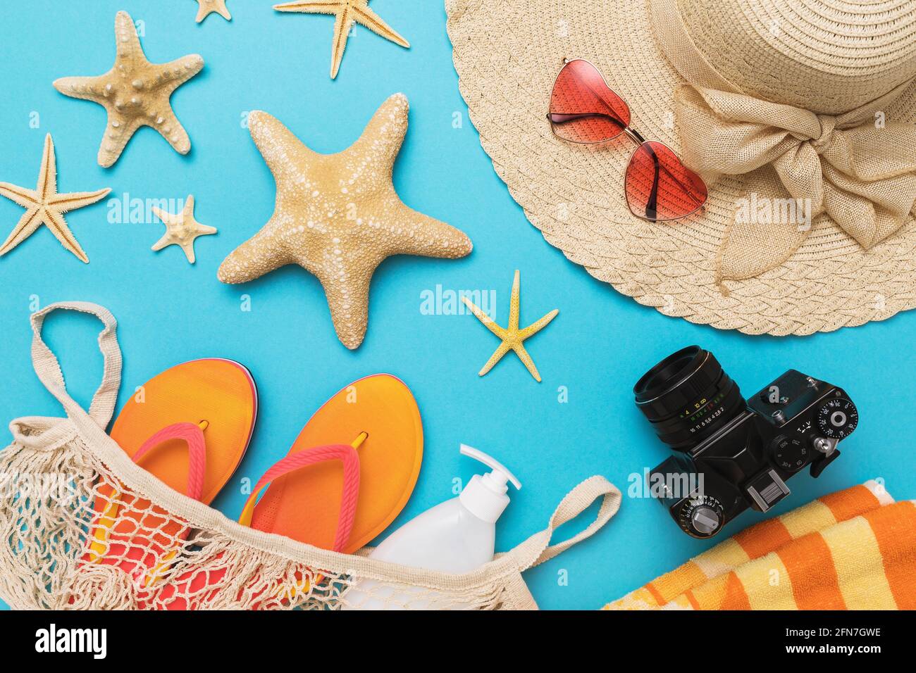Flat composition with different accessories for a beach holiday on a blue background, summer background. Stock Photo