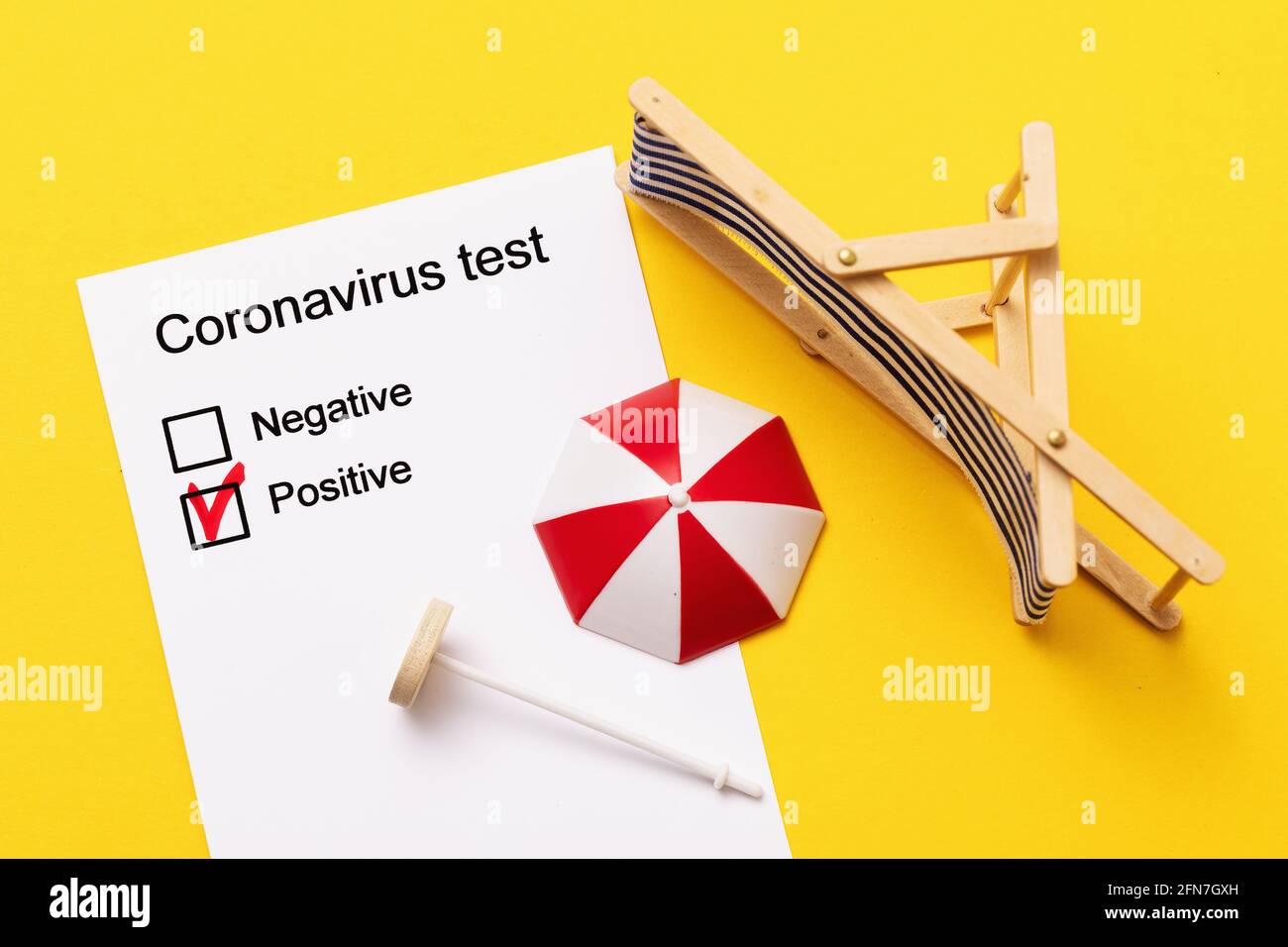 A form with positive results of the coronavirus test and inverted toy accessories for relaxation on a yellow background, a concept on the topic of spo Stock Photo