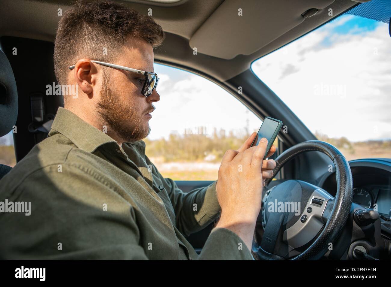 man sitting in car using phone distracted lifestyle Stock Photo