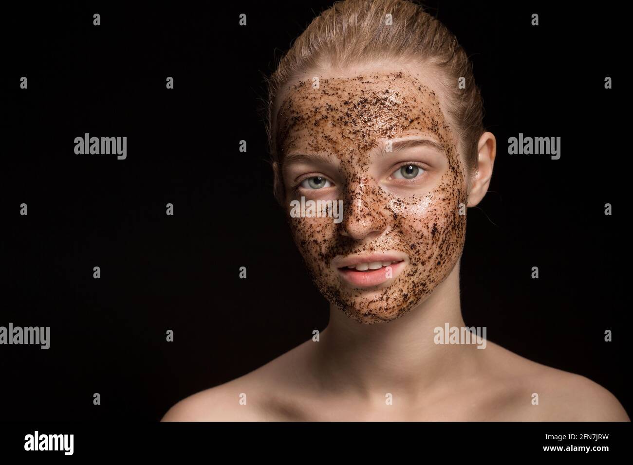 Skin scrub Coffee grounds mask on the face of a beautiful young woman