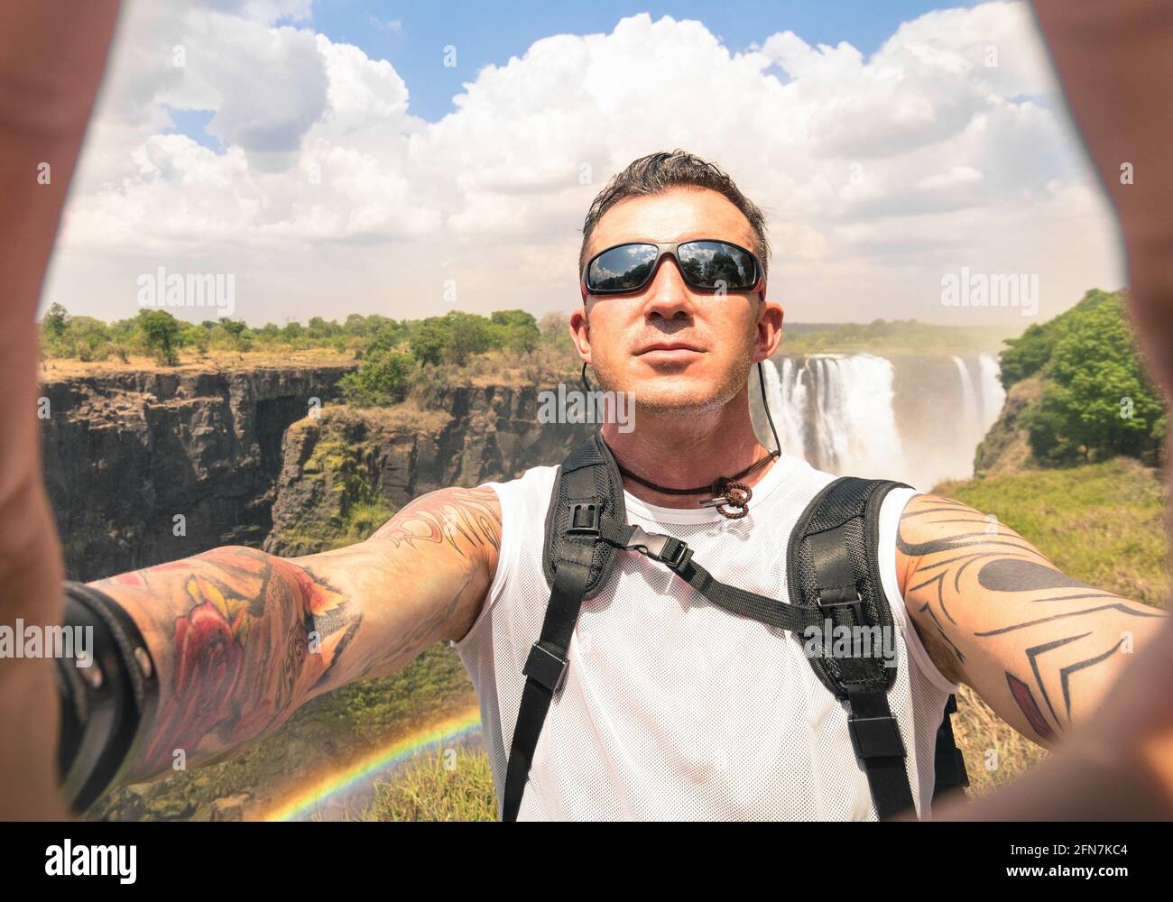 Modern hipster young man taking a selfie at Victoria Waterfalls - Adventure travel lifestyle enjoying moment of connection with nature Stock Photo