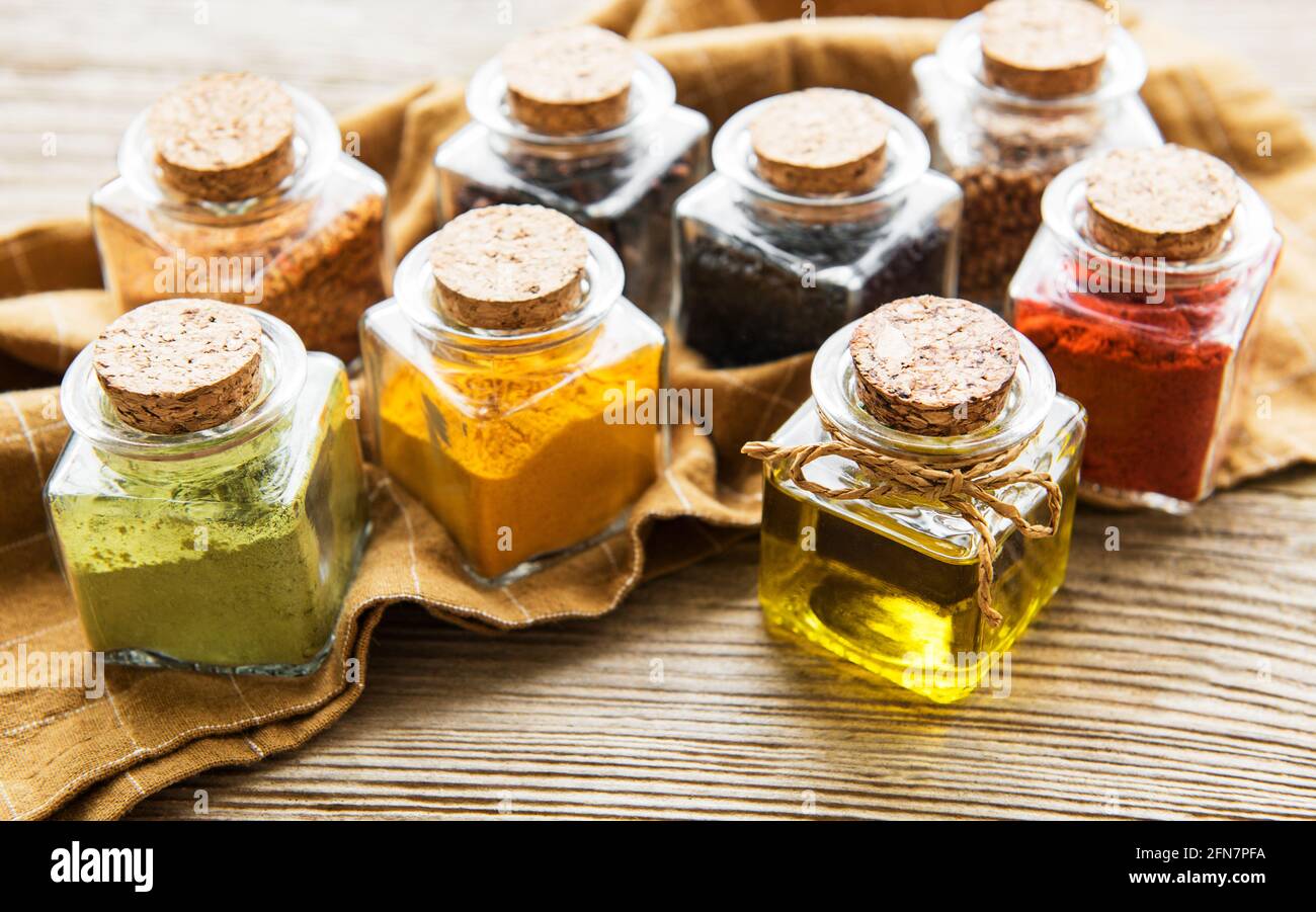 Jars with dried herbs, spices on the table Stock Photo