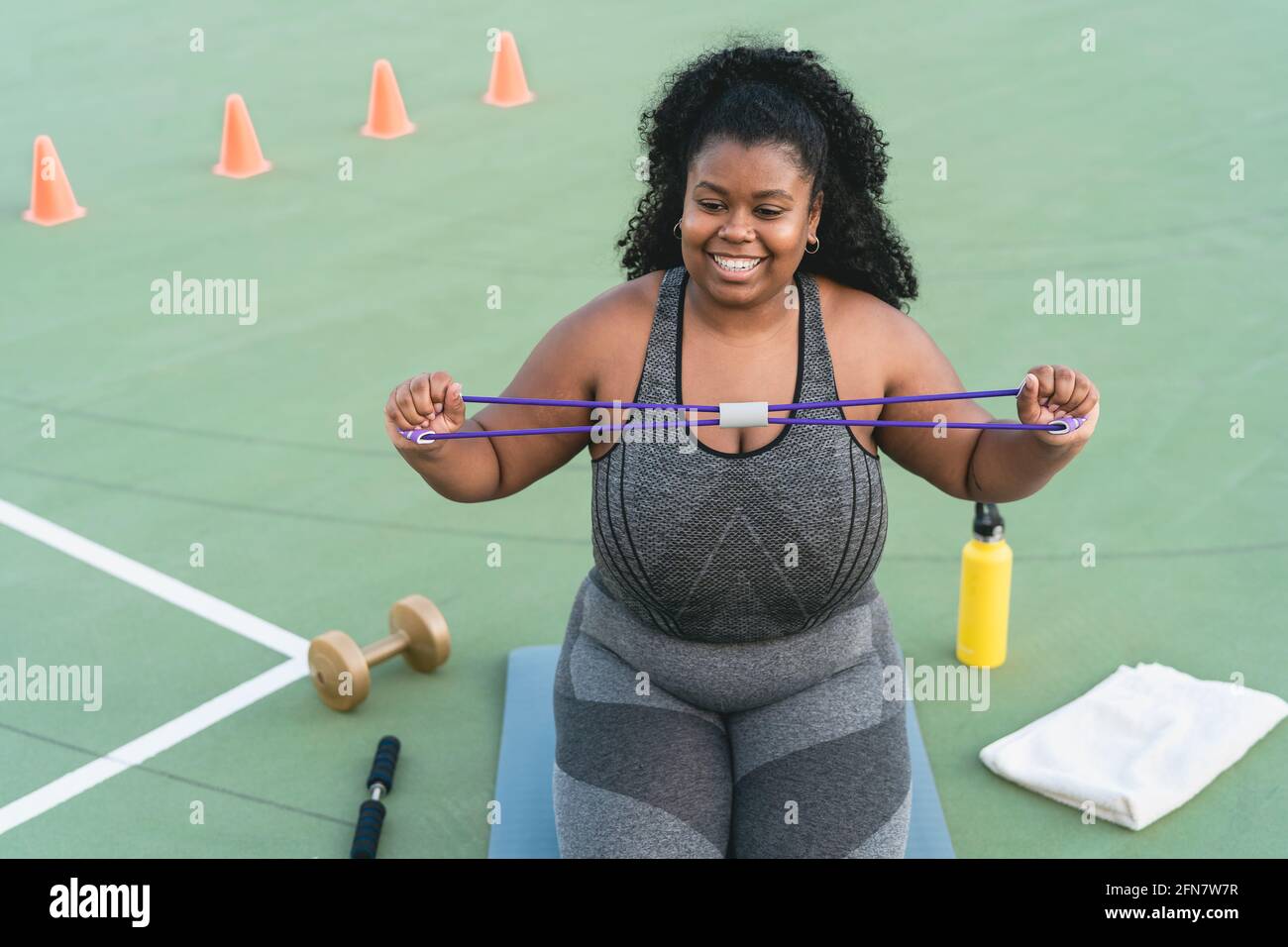 Curvy Afro woman doing workout exercises session - Young African female ...