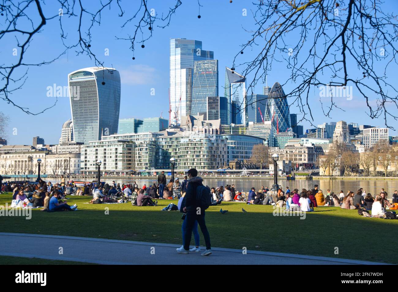 People in Potters Fields Park with a view of the City of London skyline ...