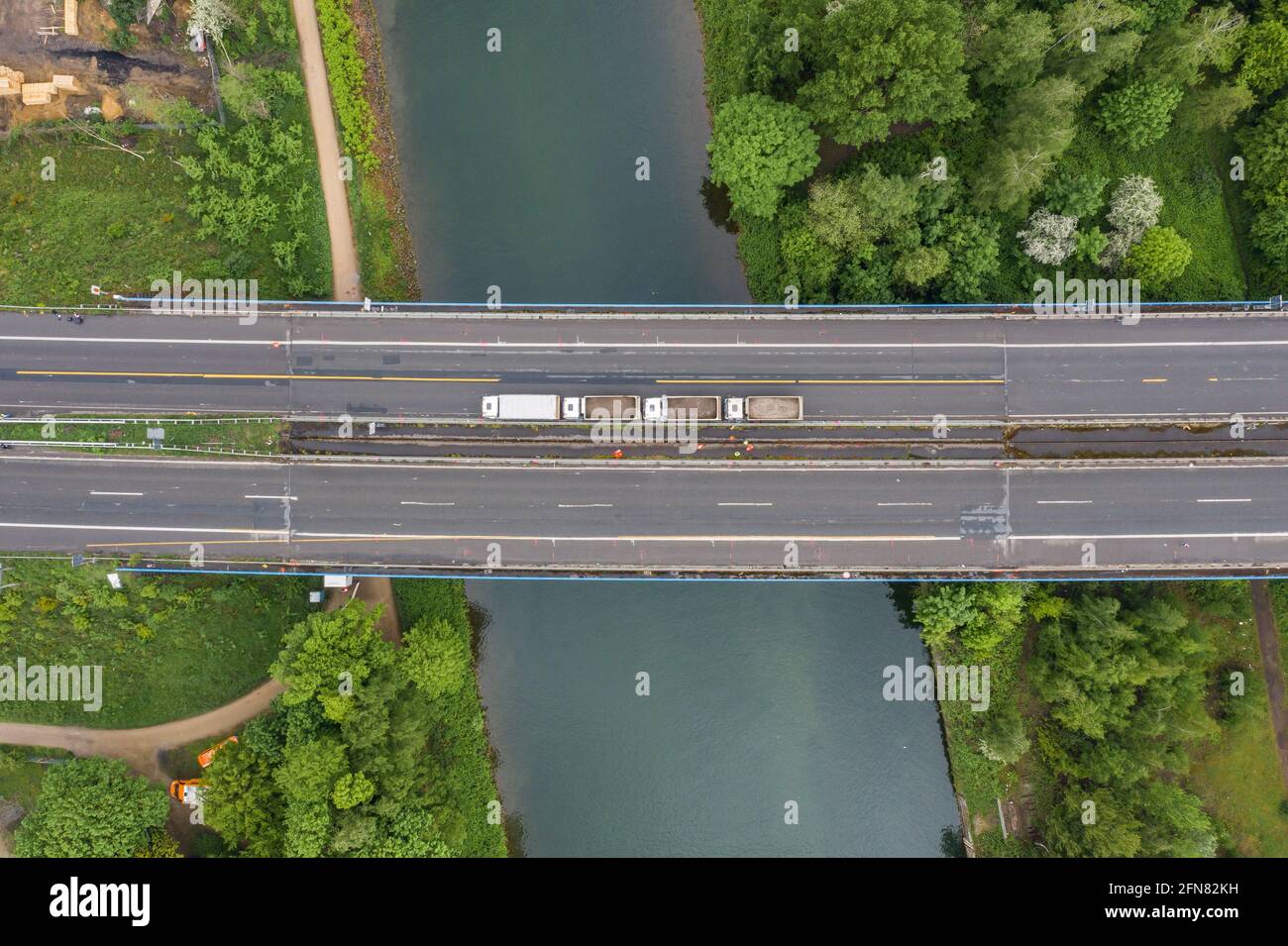 Herne, Germany. 15th May, 2021. Trucks park on the damaged A43 Emschertal Bridge during a load test (aerial photo with drone). Because the steel girders of the bridge over the Rhine-Herne Canal have buckled due to excessive loads in recent years, the bridge is already closed to trucks weighing more than 3.5 tons. From Friday (14.5.) 10 p.m. to Monday (17.5.) 5 a.m. and from Friday (21.5.) 8 p.m. to Tuesday (25.5.) 5 a.m. the stretch between the Herne and Recklinghausen motorway junctions will be completely closed. Credit: Marcel Kusch/dpa/Alamy Live News Stock Photo