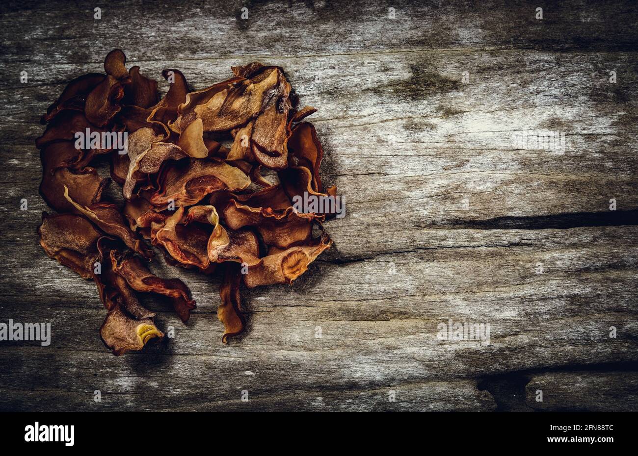Top view. Dry garcinia cambogia fruit on wood background. Garcinia atroviridis is a spice plants and high vitamin C and hydroxy citric acids (HCA) for Stock Photo