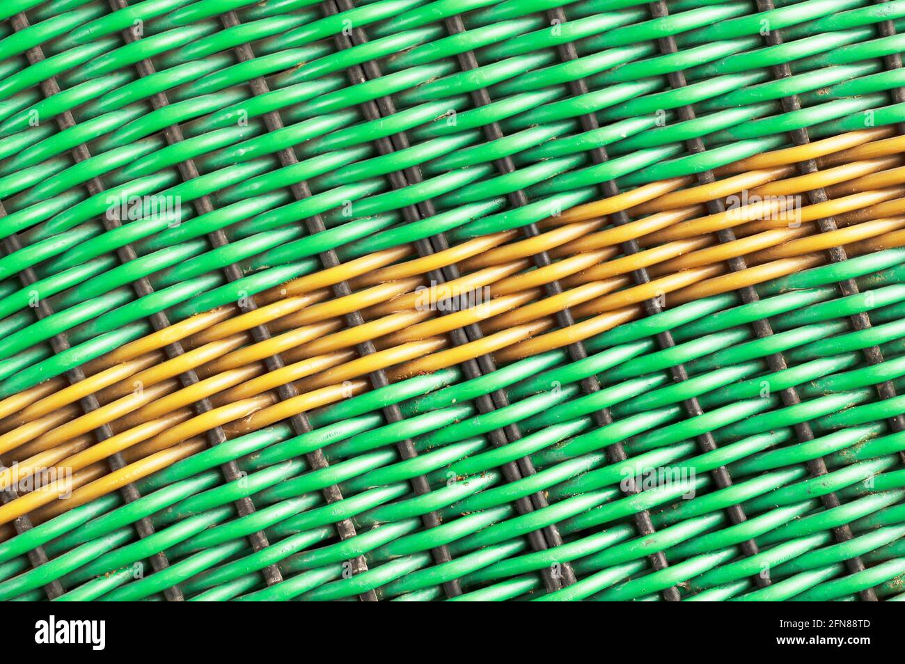 Green plastic woven background with a yellow diagonal line Stock Photo