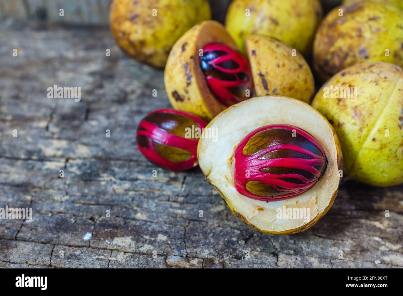 Pile of fresh nutmeg fruit with red placentalike cover of seed of