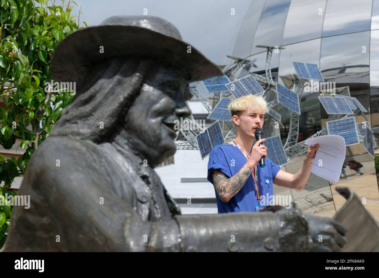 Bristol, UK. 15th May, 2021. The group “NHS Workers say no” met in Millenium Square Bristol to protest their poor pay. Speaker Alex Oldham framed by William Penn. They want a 15% restorative pay rise to make up for years of austerity. Credit: JMF News/Alamy Live News Stock Photo