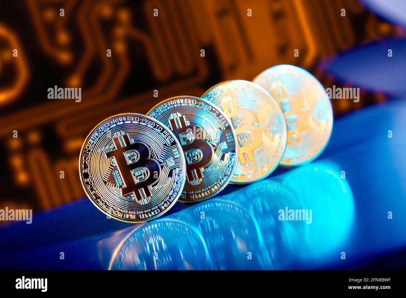 Bitcoin cryptocurrency coins against circuit board pattern Stock Photo