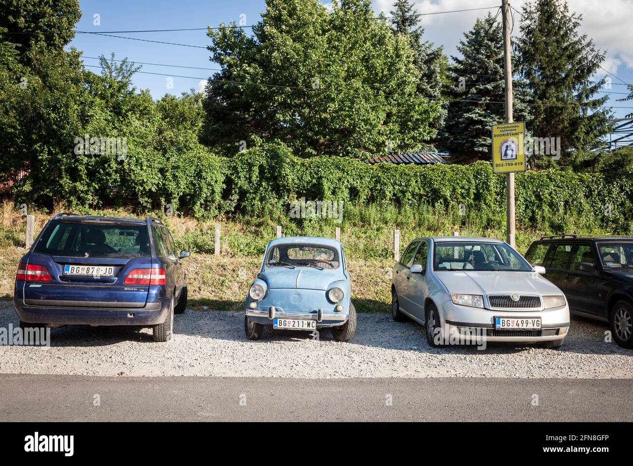 Picture of a blue vintage Zastava 750 car parked near more modern cars in a parking lot of Belgrade, Serbia. The Zastava 750 was a supermini made by t Stock Photo