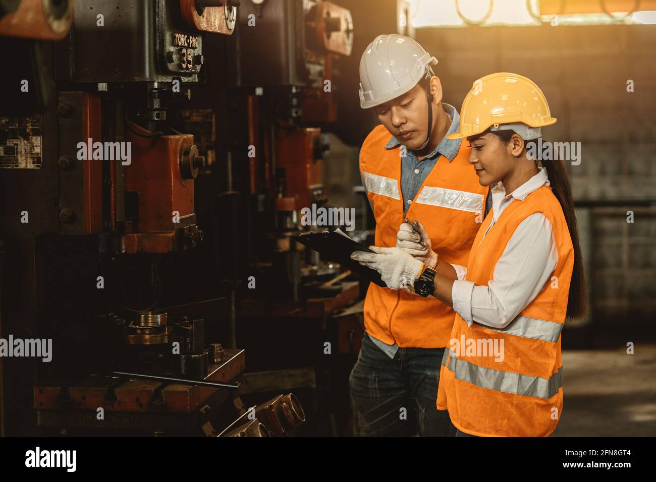 Engineer team male working with women work help support together in heavy industry teach and training machine operation in factory Stock Photo