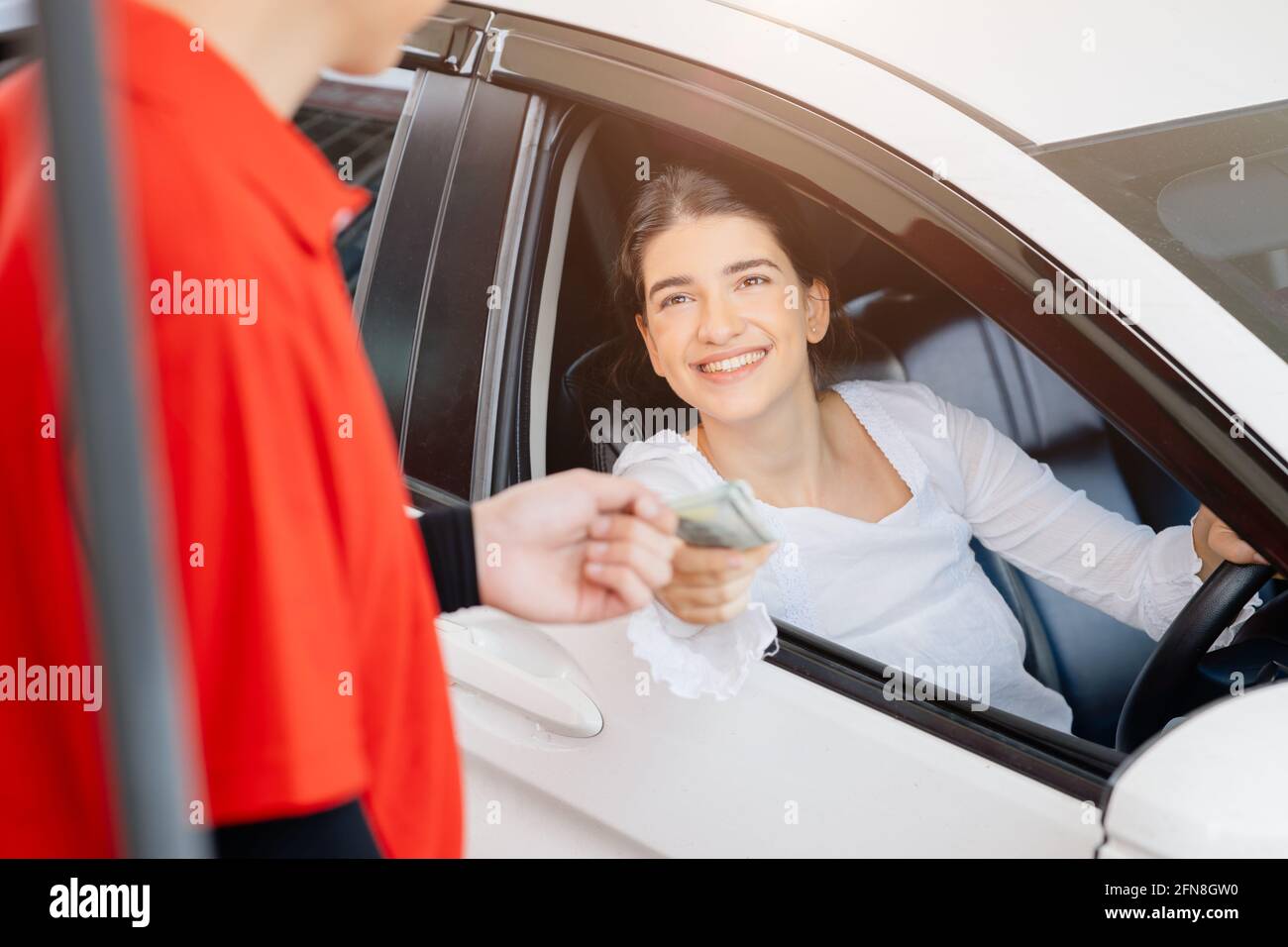 Driver customer pay fuel cost by credit card to staff worker for in gas station happy smile. Stock Photo