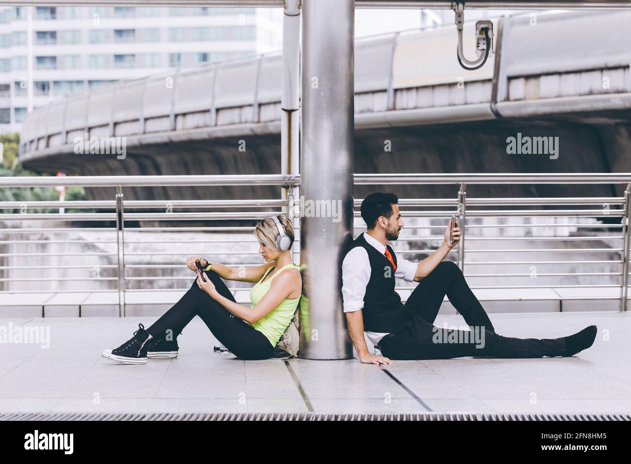 Two people with unique difference lifestyle compare both sport girl and businessman using smartphone. Stock Photo
