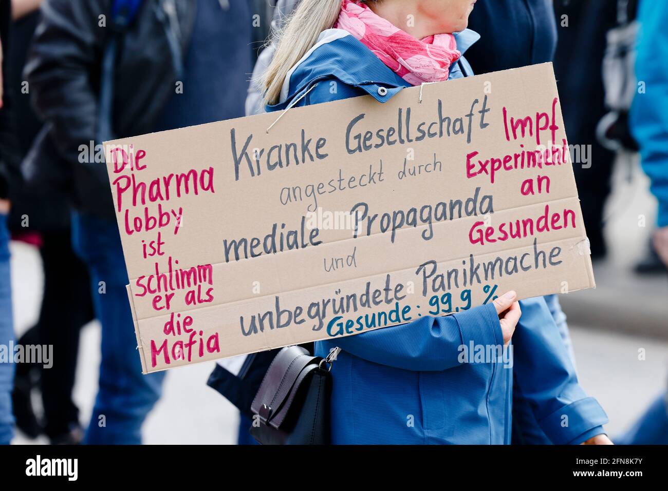 Kiel, Germany. 15th May, 2021. A participant walks along the Kiellinie with a sign written all over it during a demonstration of the so-called Querdenker scene. Credit: Frank Molter/dpa/Alamy Live News Stock Photo