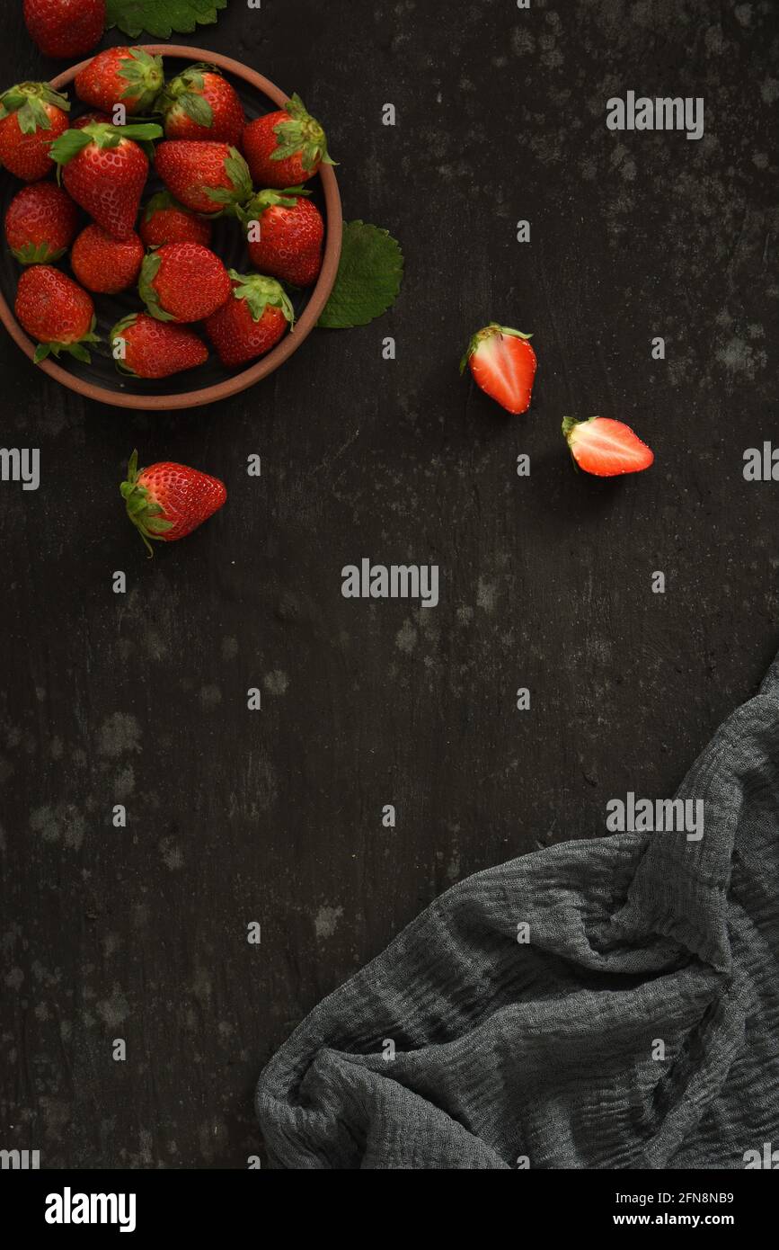 Dark Black Strawberry Cranberry In Bowl Food Flat Lay with Cutting Board and Cloth Stock Photo