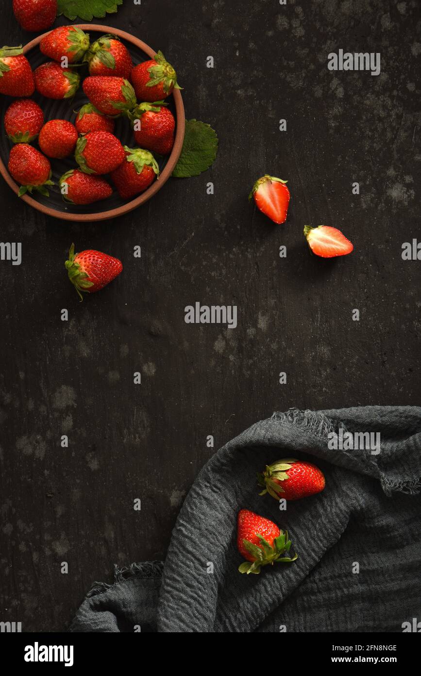 Dark Black Strawberry Cranberry In Bowl Food Flat Lay with Cutting Board and Cloth Stock Photo