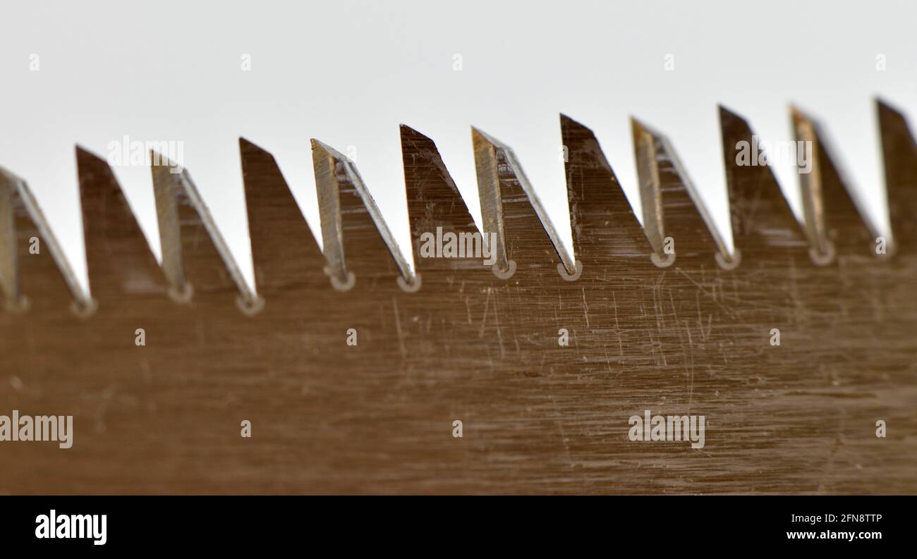 An extreme close up image of the teeth of a pull saw Stock Photo