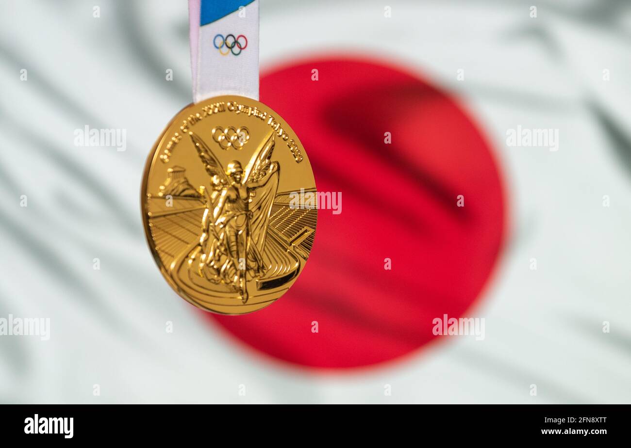 April 25, 2021 Tokyo, Japan. Gold medal of the XXXII Summer Olympic Games 2020 in Tokyo on the background of the flag of Japan. Stock Photo