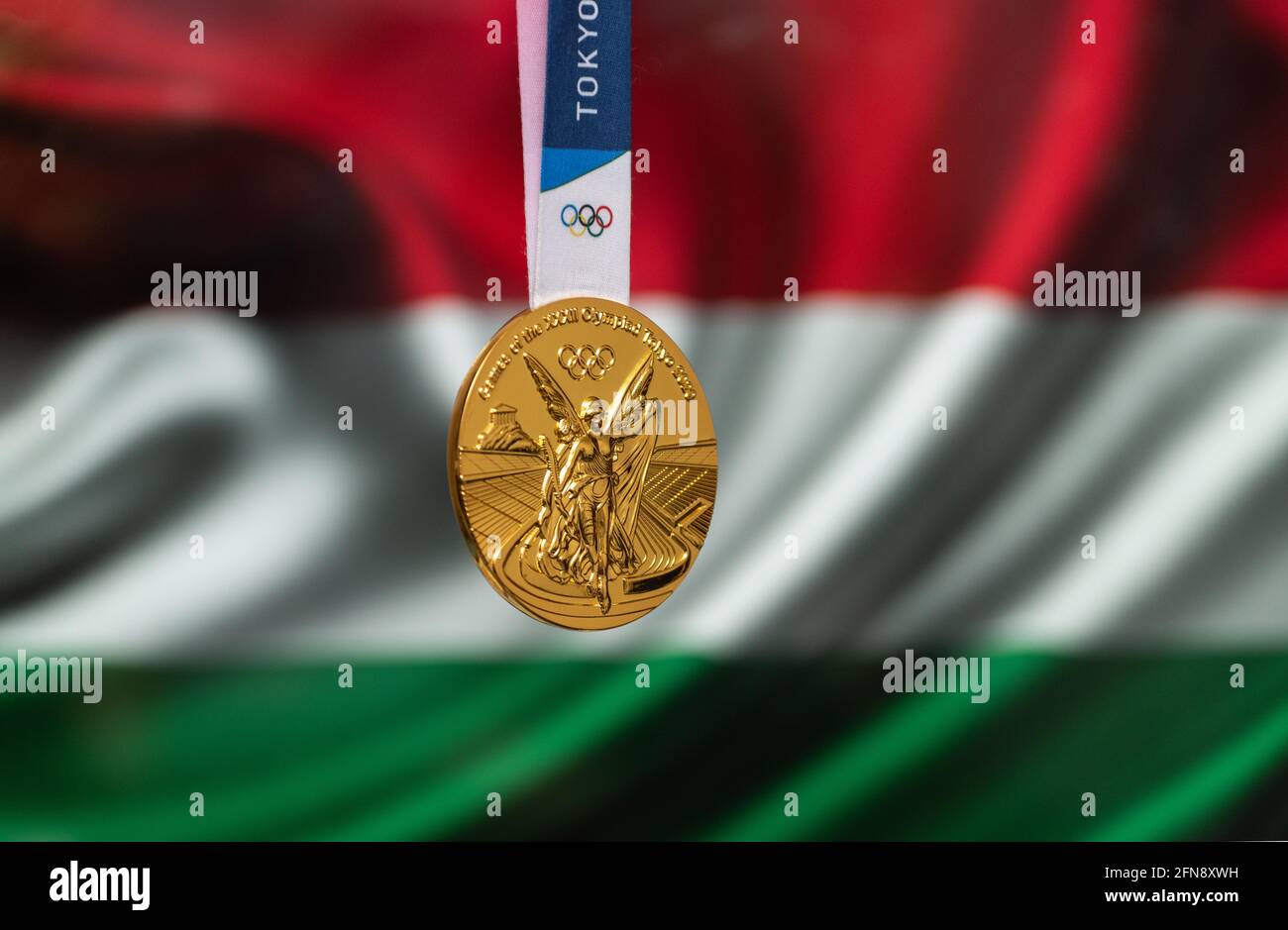 April 25, 2021 Tokyo, Japan. Gold medal of the XXXII Summer Olympic Games 2020 in Tokyo on the background of the flag of Hungary. Stock Photo