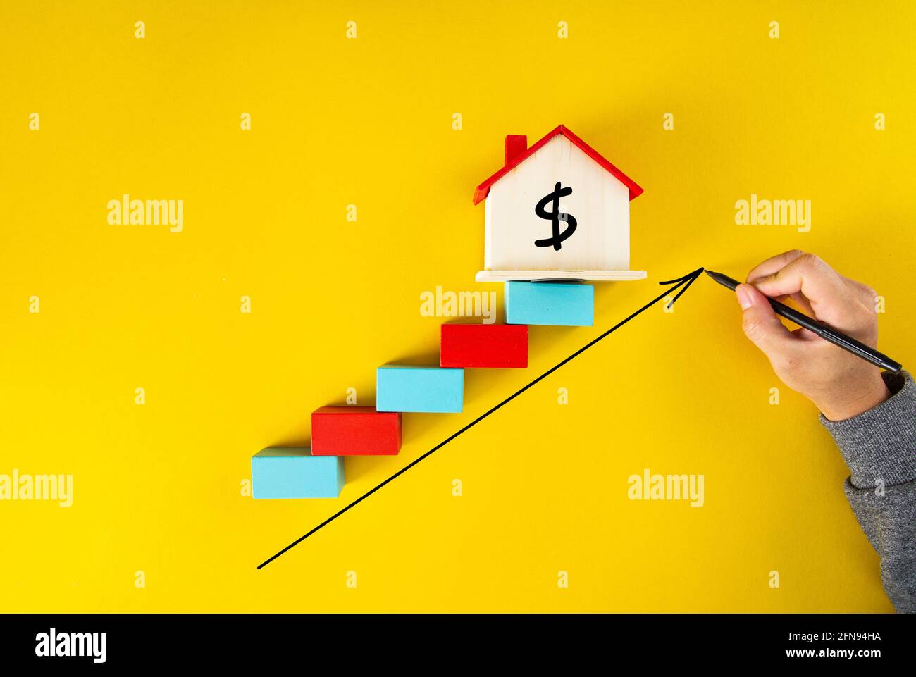 businessman drawing an arrow up above the houses. The concept of growth in demand for real