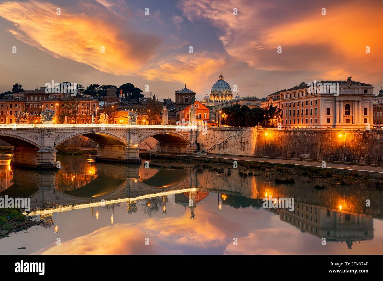 View of the Tiber River and Saint Peter's Basilica at sunset in Rome Italy Stock Photo