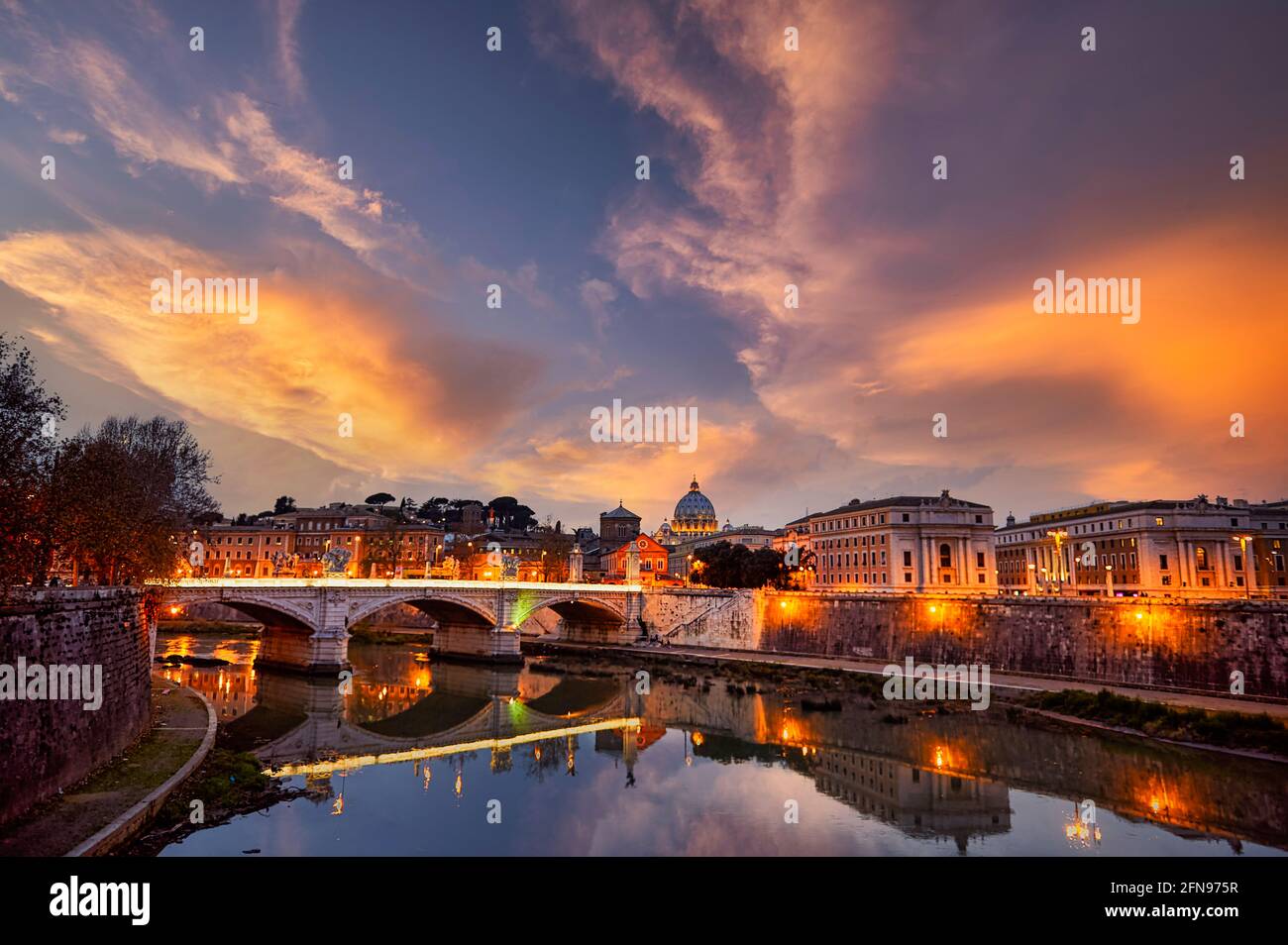 View of the Tiber River and Saint Peter's Basilica at sunset in Rome Italy Stock Photo