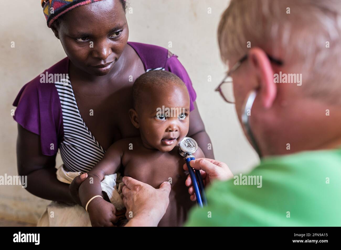 Foreign doctor is examining a toddler in a medical clinic in Mbale, rural Eastern Uganda Stock Photo