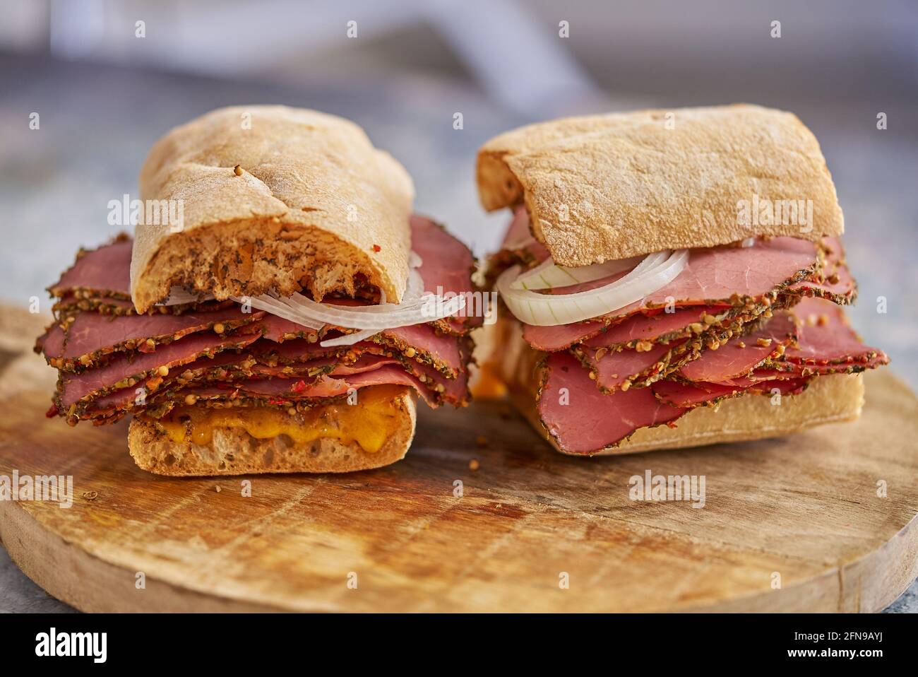 Thin cut pastrami sandwhich with delicious meet on baguette bread with