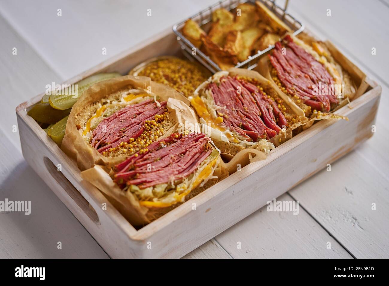 Enormous sandwiches with pastrami beef in wooden box. Served with baked