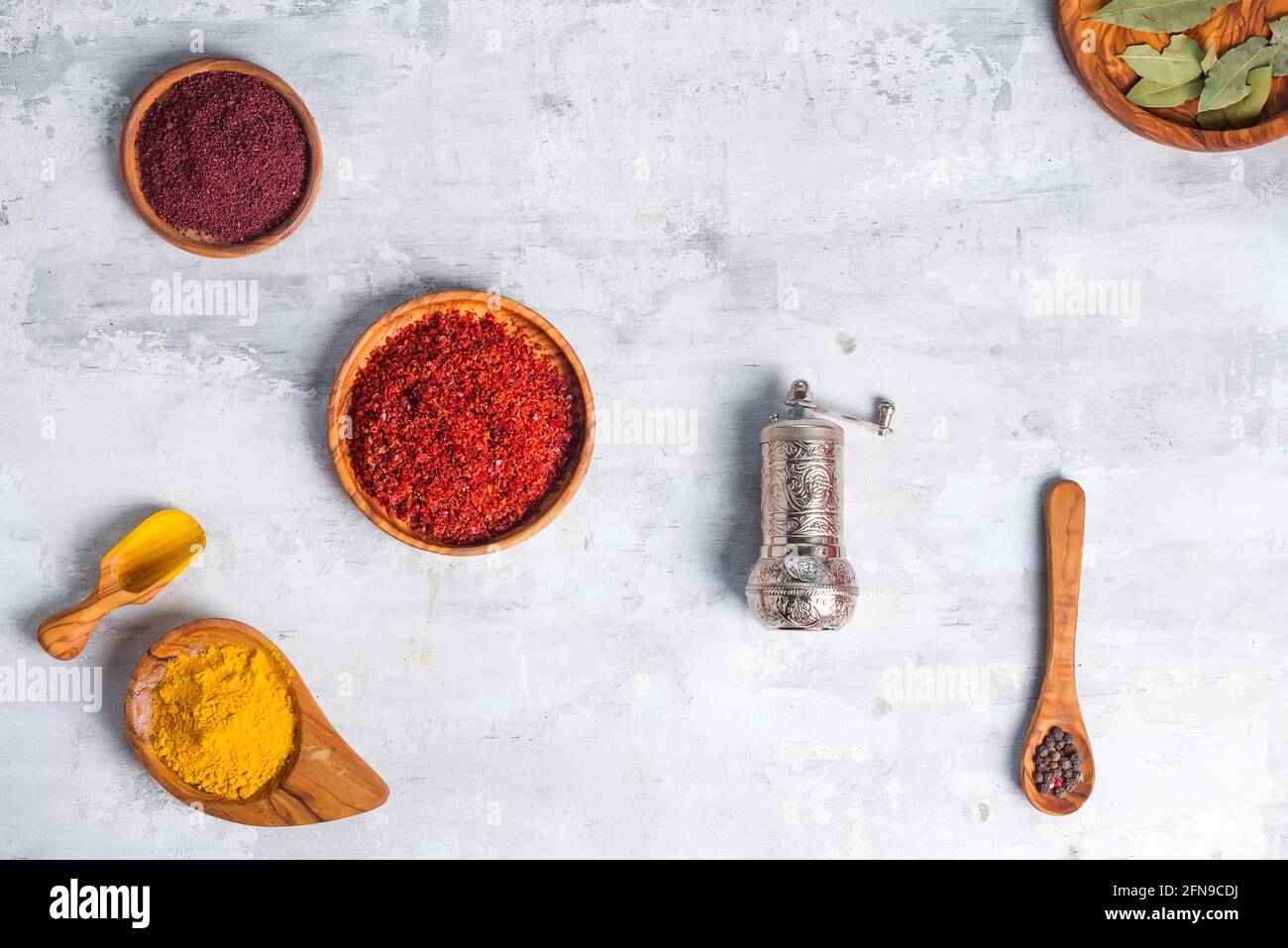 Dried kinds of spices of different grinding in wooden bowl with handle grinder on stone , flat