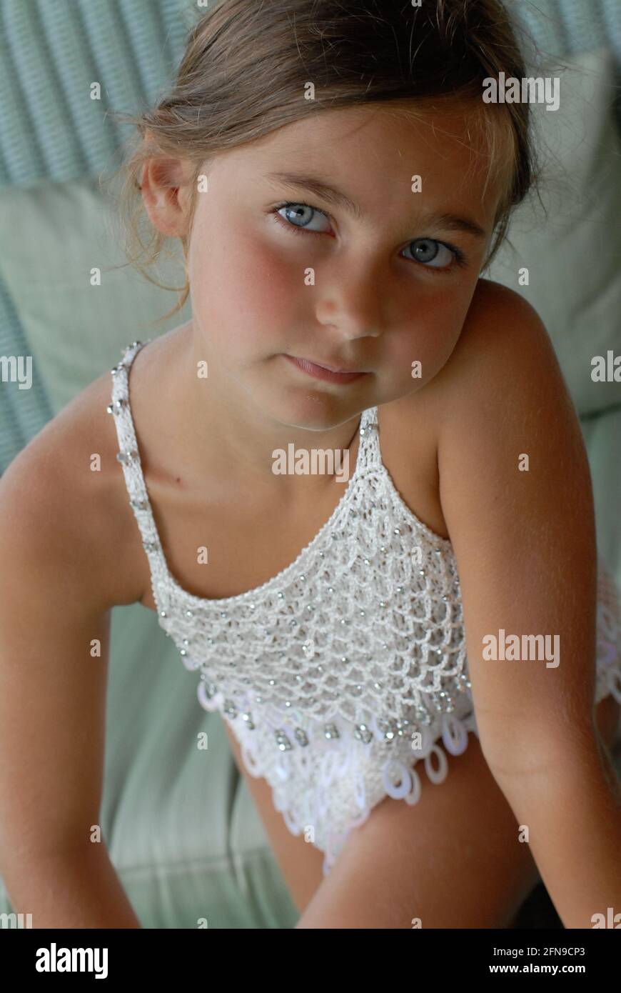 Little girl blonde hair, blue eyes and white dress, that makes grimaces, italian little girl, Italy Stock Photo